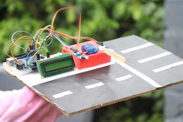 Holding a toll tax barrier project that uses micro servo and LCD with a controller to control the...
