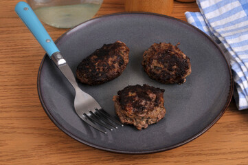 Boulettes de viande de bœuf maison servies dans une assiette avec une fourchette vue de dessus.