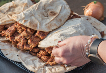 Shish kebab lula with lavash. Woman's hand takes lavash