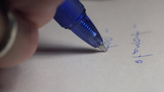 Extreme closeup shot of male hand taking notes on paper