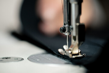 close-up in a sewing workshop thread is inserted into a needle on a machine