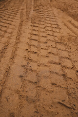 Sand tyre mark background. Tire tracks and footprints on beach sand. Machine Imprints.