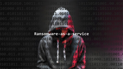 Cyber attack ransomware-as-a-service text in foreground screen, anonymous hacker hidden with hoodie in the blurred background. Vulnerability text in binary system code on editor program.