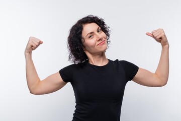 Caucasian woman with black curls shows her strong muscles