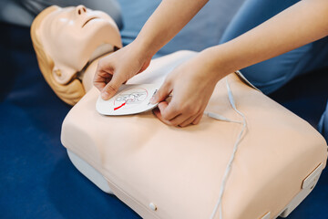 Medical student placing an AED pad on a manikin during medical training