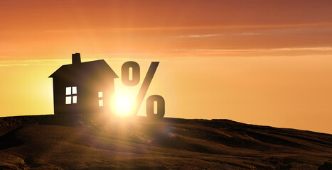 Percent sign and model of house on bright sunset background. House Mortgage Loan. House and...