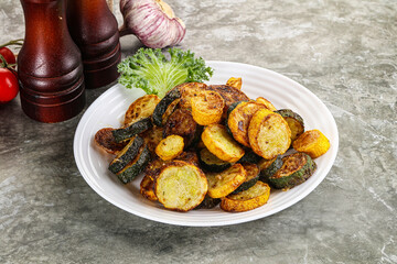 Roasted young zucchini in the plate