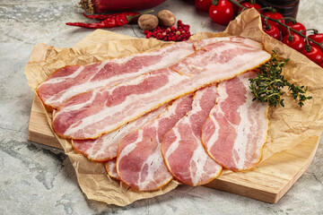 Sliced pork bacon over board