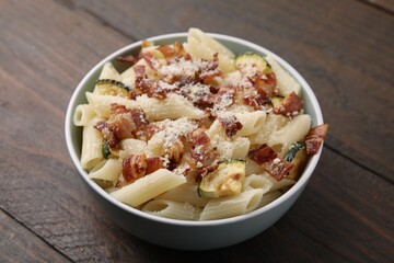 Tasty pasta with bacon and cheese on wooden table, closeup
