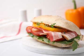 Tasty sandwich with bacon and bell pepper on white table, closeup