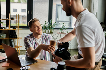 Two men in cozy outfits collaborating, camera in hand.