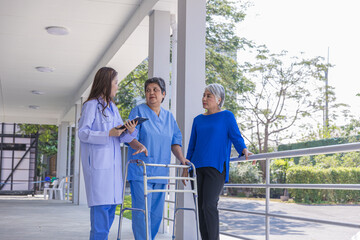 doctor or nurse helping Senior man to walk at nursing home with walker. Doctor or  nurse helping...