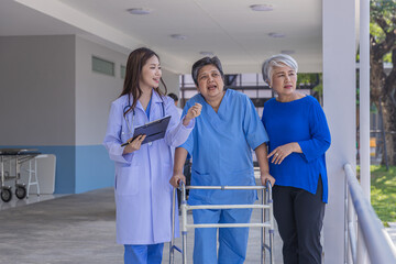 doctor or nurse helping Senior man to walk at nursing home with walker. Doctor or  nurse helping...