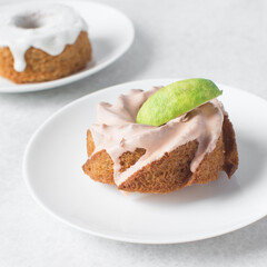 Iced mini bundt cake on a white plate, vanilla citrus bundlette on a plate, small vanilla bundt cake with an icing glaze