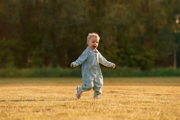 Having fun, running. Little boy is on the summer field