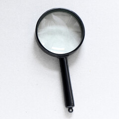 Black magnifier on a gray background.