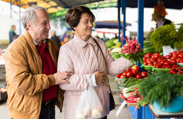 Elderly men and women buying radishes at the open market