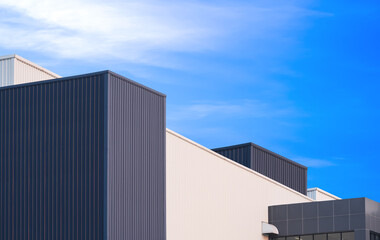 Fototapeta premium Black and white aluminium wall of modern industrial factory buildings in minimal style against blue sky background, Low angle and perspective side view with copy space