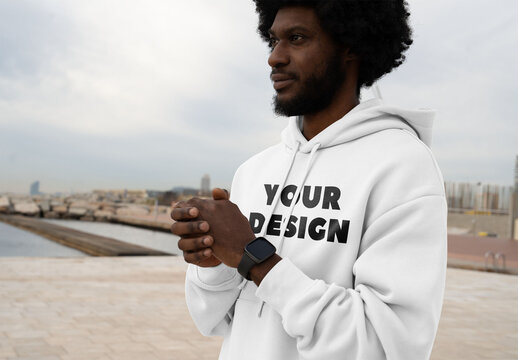 Mockup of man wearing customizable hoodie, hands clasped