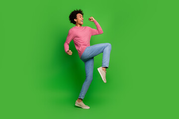Full length photo of lucky cool guy dressed pink pullover rising fists emtpy space isolated green...
