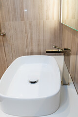 Stylish white sink with a modern faucet in the interior of the bathroom.