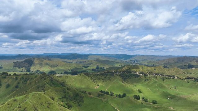 Aerial approaches the steep grassed hillsides of the Strathmore Saddle marked by trees on the ridgeline and State Highway 43, the Forgotten World Highway. Gullies and larger valleys feature.