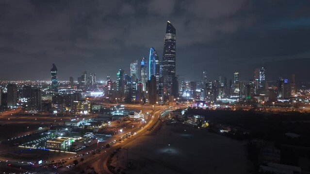 Night cityscape, illuminated and flashing lights skyscrapers. Kuwait City downtown. Drone crane.