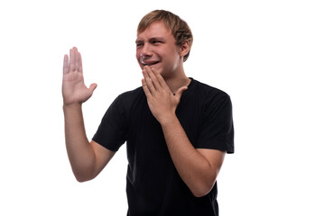A cute teenage guy with blond hair dressed in a black T-shirt is thinking about an idea