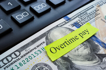 Money, calculator and overtime pay sign.
