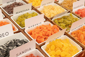 Colorful assorted gummy candies on trays for sale on spanish marketplace. Full frame