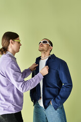 Two men stand before a vibrant yellow backdrop.