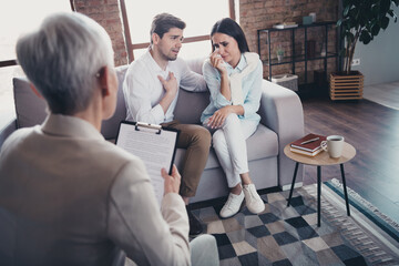 Portrait of young married couple sit couch cry consultation visit psychotherapist loft interior...