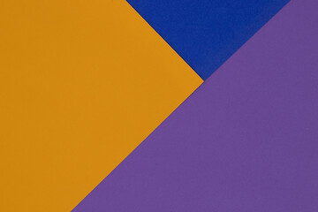 Geometric background, blue, purple and orange triangles made of textured paper arranged in...
