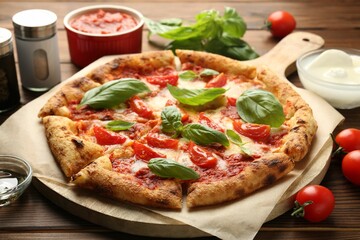 Delicious Margherita pizza and ingredients on wooden table