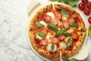 Delicious Margherita pizza and ingredients on white marble table, top view. Space for text