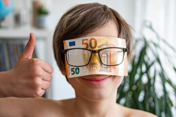satisfied child inserted euro banknotes into glasses, euro money, rejoices in success, anticipates...