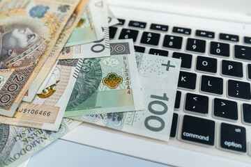 Polish 100 200 zloty polish money on laptop keyboard. Close up