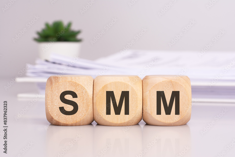 Poster SMM 'Social Media Marketing' - text on wooden cubes on the gray table. business concept