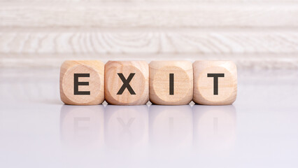the word exit is written on a wooden blocks structure. Blocks on a bright gray background. selective focus
