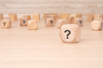 wooden cubes with a question mark engraved on them, front view