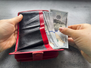 woman takes out us dollar banknotes from a wallet. Rich businesswoman with money