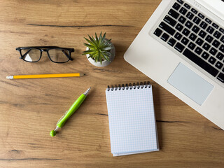 Workplace with laptop, empty notepad  office supplies on office desk. Creative background