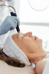Close-up of elderly, senior woman getting facial hydro microdermabrasion peeling treatment