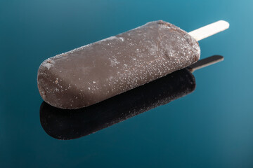 chocolate outer popsicle on blue background with reflection
