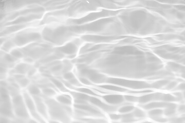 White water with ripples on the surface. Defocus blurred transparent white colored clear calm water surface texture with splashes and bubbles. Water waves with shining pattern texture background.
