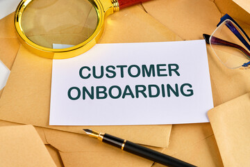 Concept Business. CUSTOMER ONBOARDING symbol on a blank sheet near a pen, magnifying glass and...