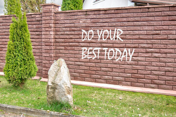 Business motivational. Do your best today symbol writing on a red brick fence
