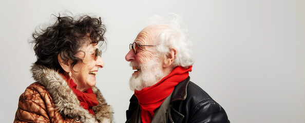 Elderly funny laughing couple in a good mood, on grey bacjground, copyspace, banner