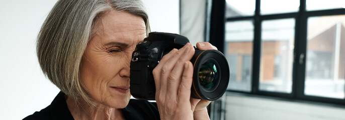 Middle-aged woman in a photo studio taking a picture with a camera.
