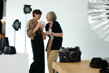Middle-aged lesbian couple in a studio, focus on camera
